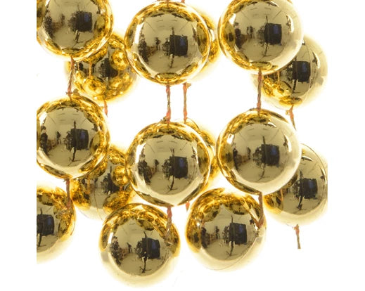 Close-up of shiny light gold polystyrene bead garland with reflective spherical beads on string.