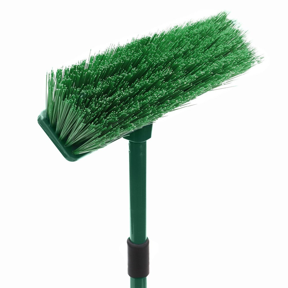 Close-up of The Gardener hard bristle broom head with green bristles and part of the extendable handle visible