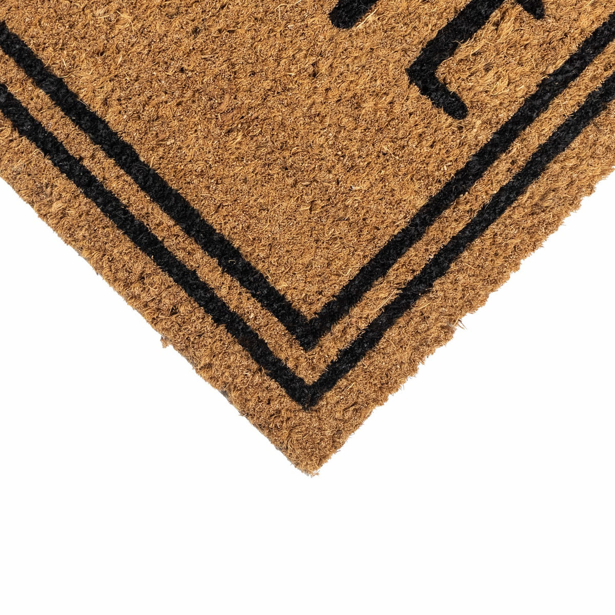Close-up of the corner of a latex-backed coir doormat with black double border lines.