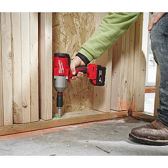 Milwaukee M18 BLHIWF12-0 18V impact wrench in use driving a fastener into wood framing.