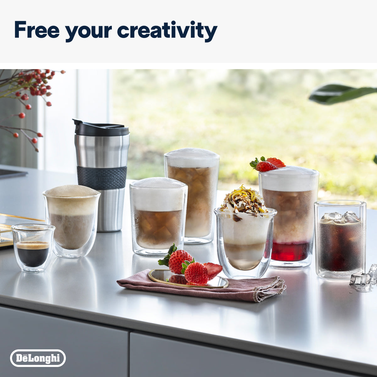 Variety of coffee drinks and a DeLonghi branded stainless steel travel mug on a kitchen counter.