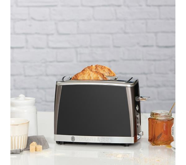 Russell Hobbs matte black 2-slice toaster with toasted bread popping up on a kitchen counter.