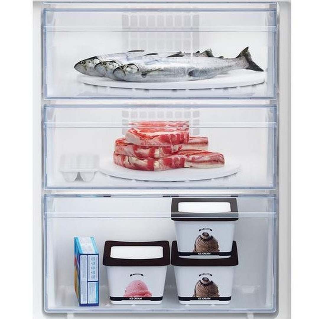 Beko Integrated 70/30 fridge freezer open showing frozen fish, meat, ice cream tubs, and a box inside compartments
