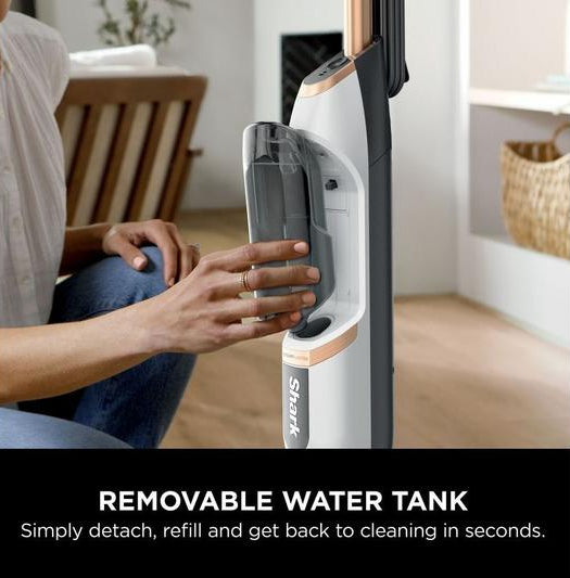 Person detaching the removable water tank from the Shark SteamSpot S2001UK steam cleaner.