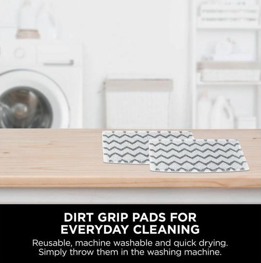 Shark SteamSpot S2001UK dirt grip pads on wooden surface with laundry room background and cleaning text.
