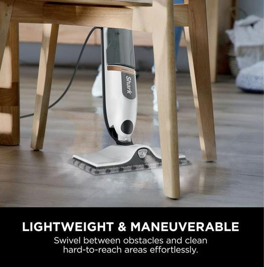 Shark SteamSpot S2001UK steam mop cleaning under a wooden chair on a hardwood floor