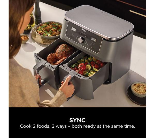 Ninja MAX 6-in-1 Dual Zone Air Fryer with two drawers cooking chicken and vegetables side by side.