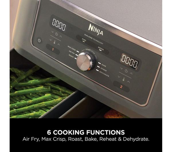 Close-up of Ninja MAX 6-in-1 Dual Zone Air Fryer control panel with cooking functions and two baskets cooking vegetables.