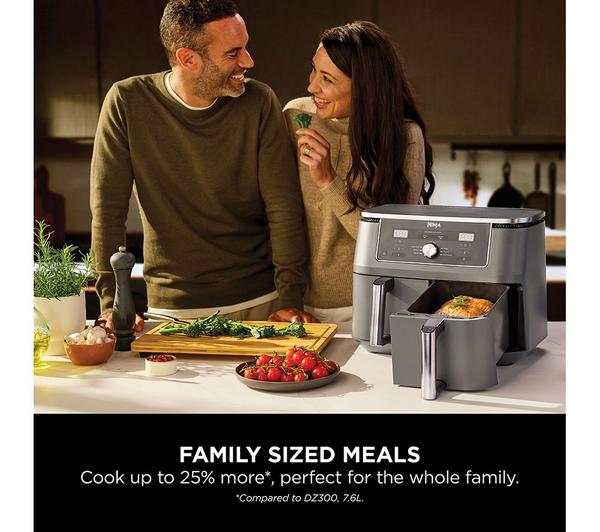 Ninja MAX 6-in-1 Dual Zone Air Fryer in dark grey with open basket cooking a whole chicken on a kitchen counter.