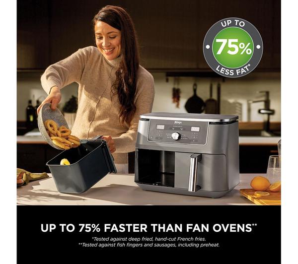 Ninja MAX 6-in-1 Dual Zone Air Fryer 9.5L in dark grey on kitchen counter with woman adding onion rings to basket