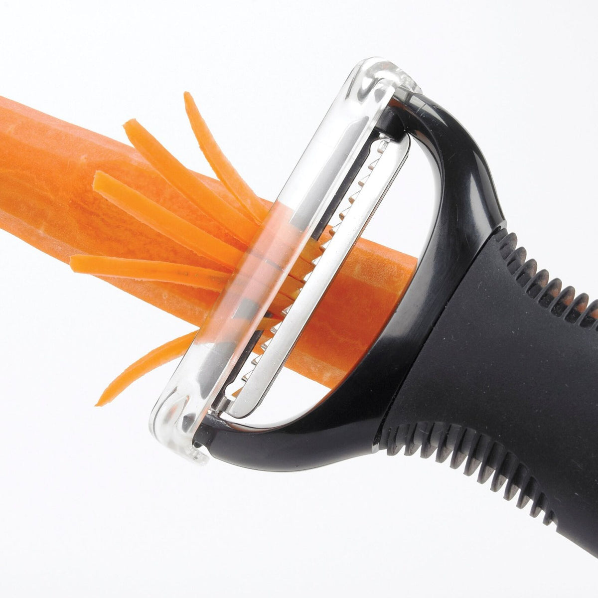 Close-up of Oxo Julienne Peeler slicing thin strips from a peeled carrot.