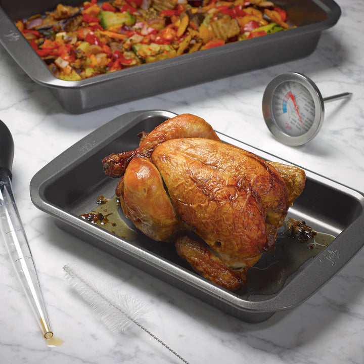 Tala 9x13" large roaster with a roasted whole chicken inside on a marble surface with a meat thermometer nearby