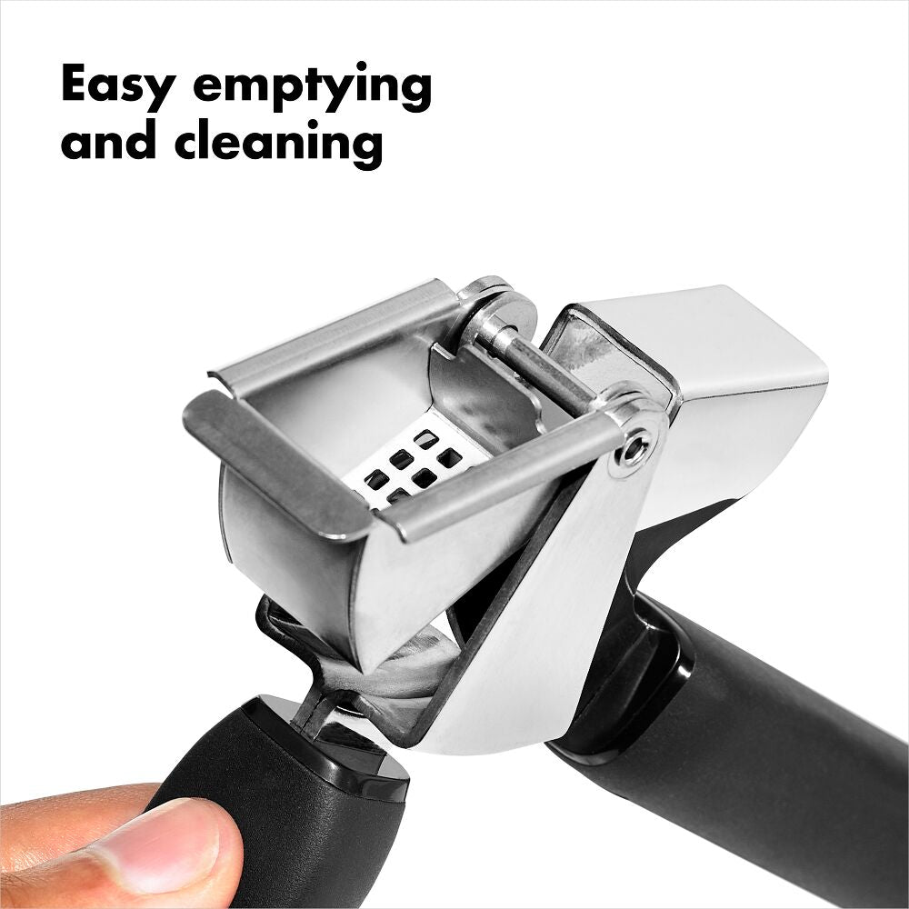 Close-up of Oxo Garlic Press showing the hinged basket for easy emptying and cleaning