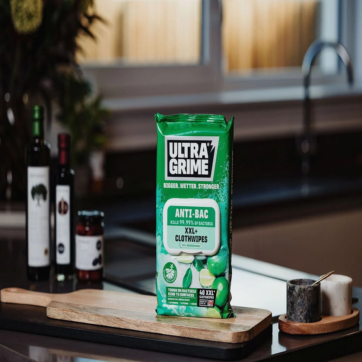 UltraGrime Anti-Bac XXL+ Clothwipes pack standing on a wooden board in a kitchen setting.