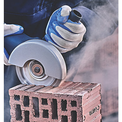 Person wearing gloves using a Bosch diamond cutting disc 115mm to cut a brick, with dust visible.