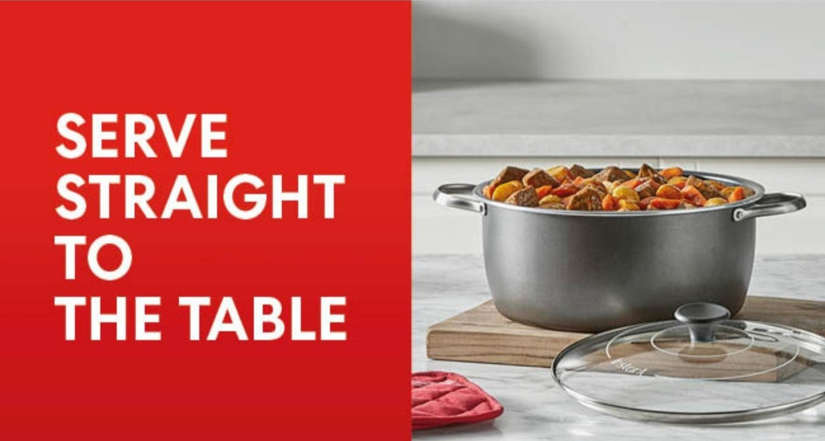 Instant Pot Superior Slow Cooker filled with stew, lid off, on wooden board with red pot holder nearby.