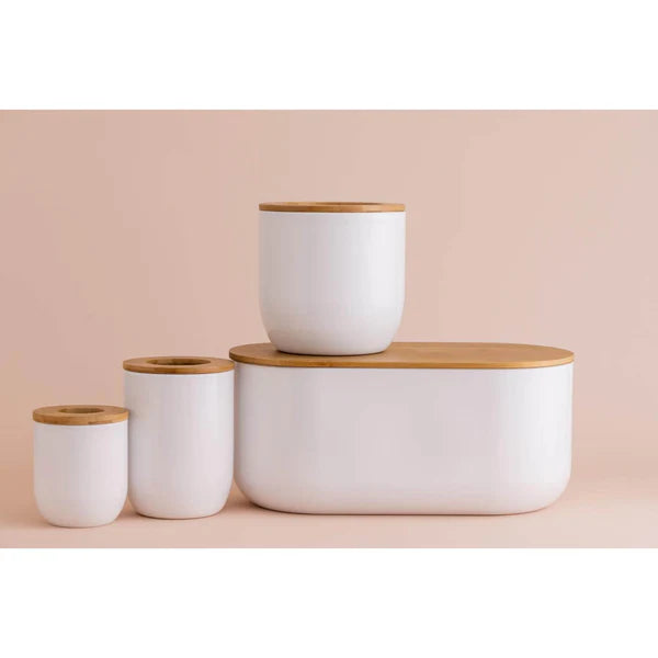 Eden White Bread Storage Bin with three matching white canisters, all with wooden lids, on a beige background