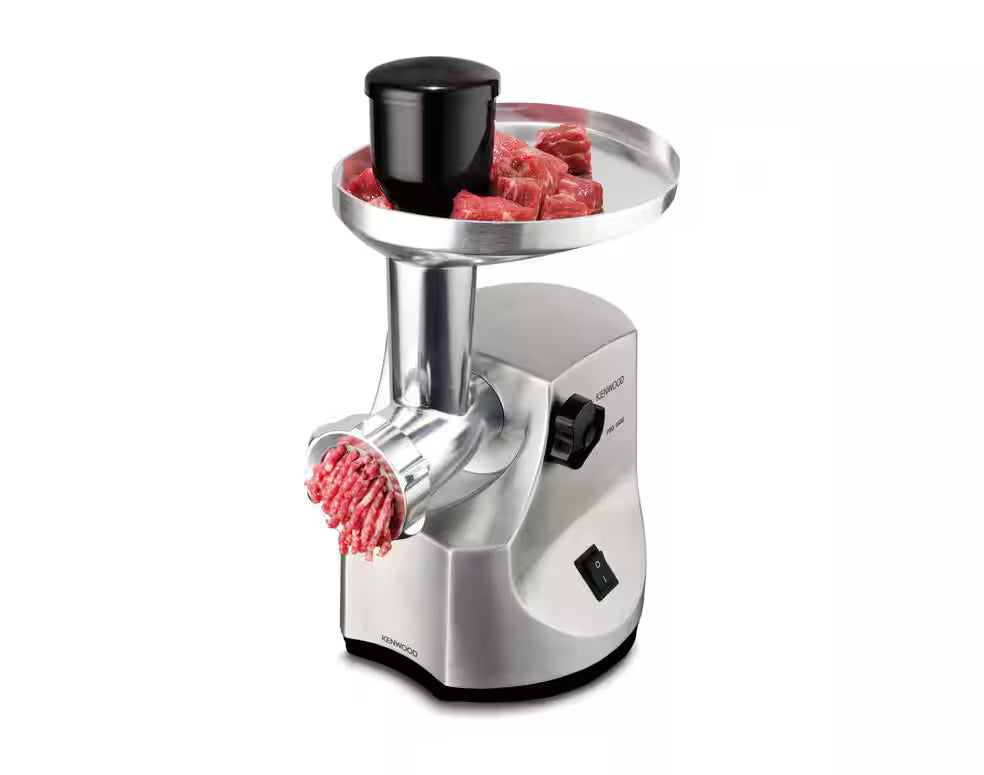 Kenwood MG510 Pro food mincer with raw meat in tray and minced meat coming out of grinder.