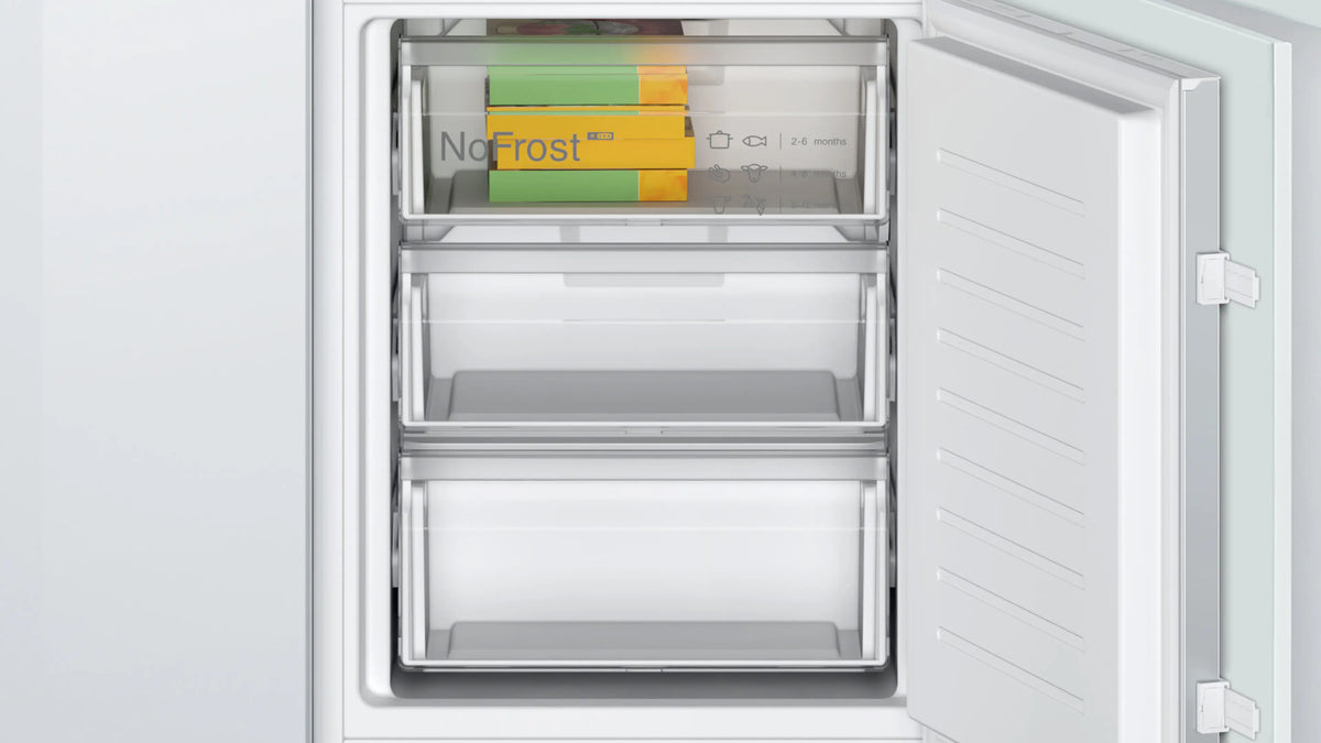 Open freezer compartment of Bosch Series 2 60/40 built-in fridge freezer with sliding hinge and frost-free drawers