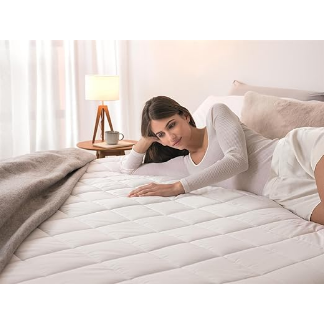 Woman lying on a bed touching the white Dreamland Mattress Cover Electric Blanket with quilted pattern