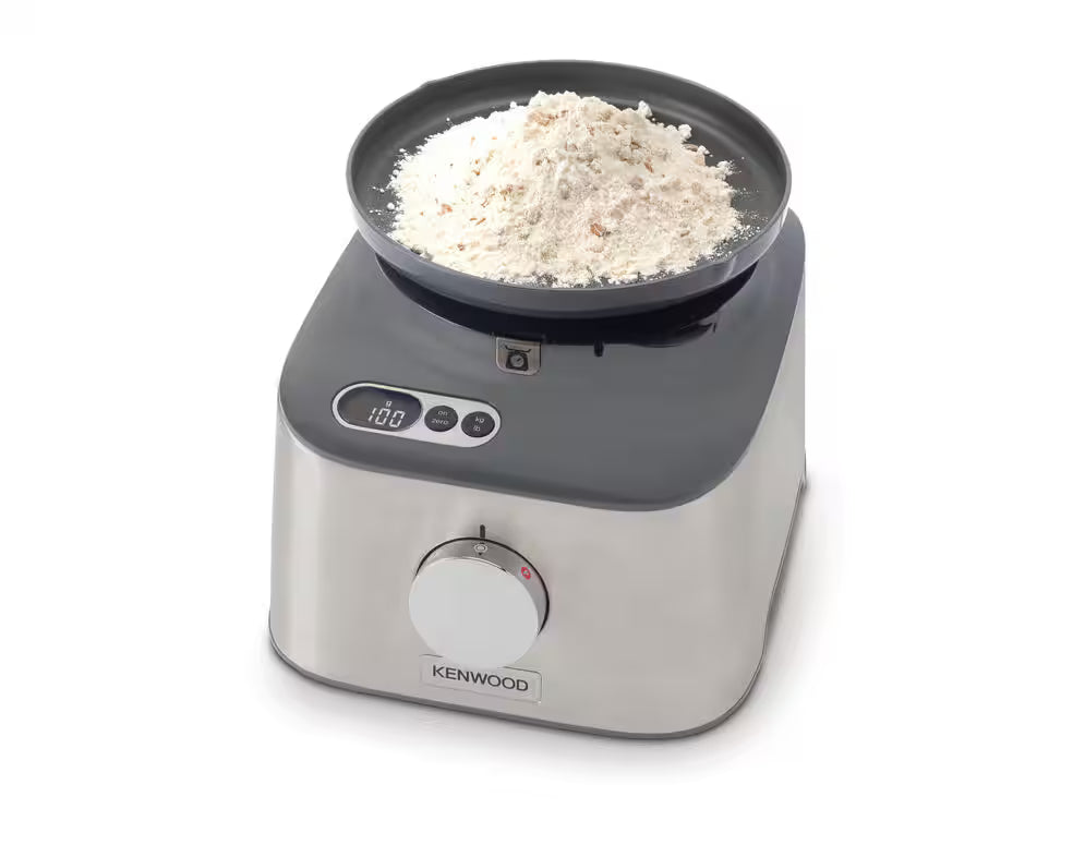 Kenwood MultiPro Compact food processor base with digital scale and bowl containing flour.