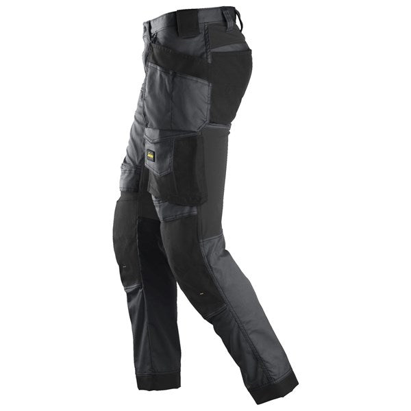 Grey Snickers All Around Stretch Trousers with reinforced black knee and pocket panels shown from side angle.