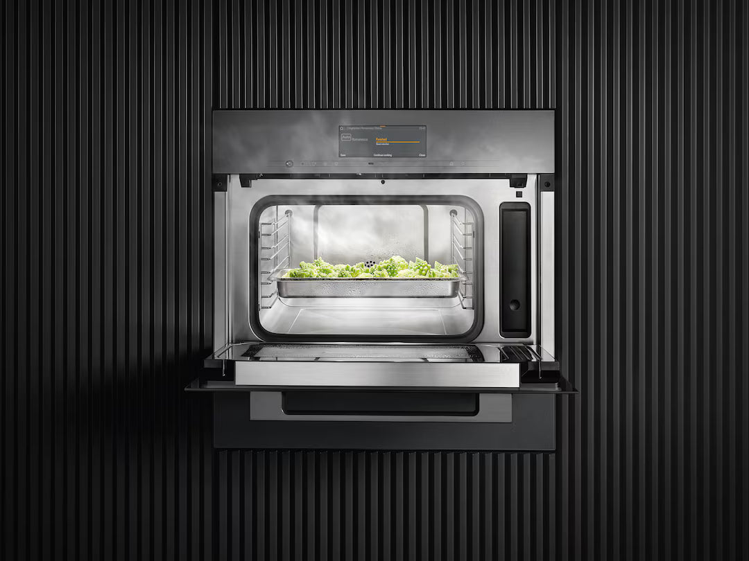 Miele DGM 7840 VitroLine steam oven microwave in obsidian black with open door and steaming vegetables inside