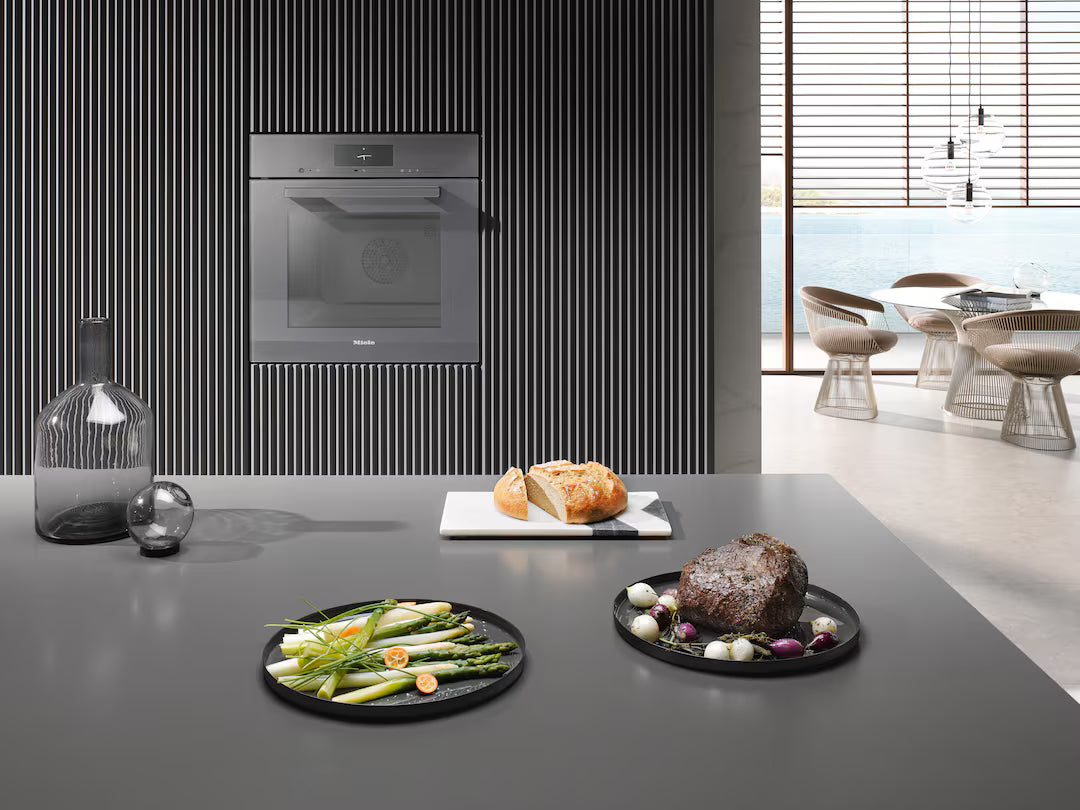 Built-in Miele DGC 7440 HC Pro VitroLine steam oven in graphite grey installed in modern kitchen wall.