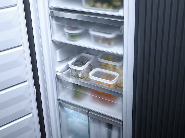 Open Miele FNS 7794 D L upright freezer showing frosted drawers with food containers inside.