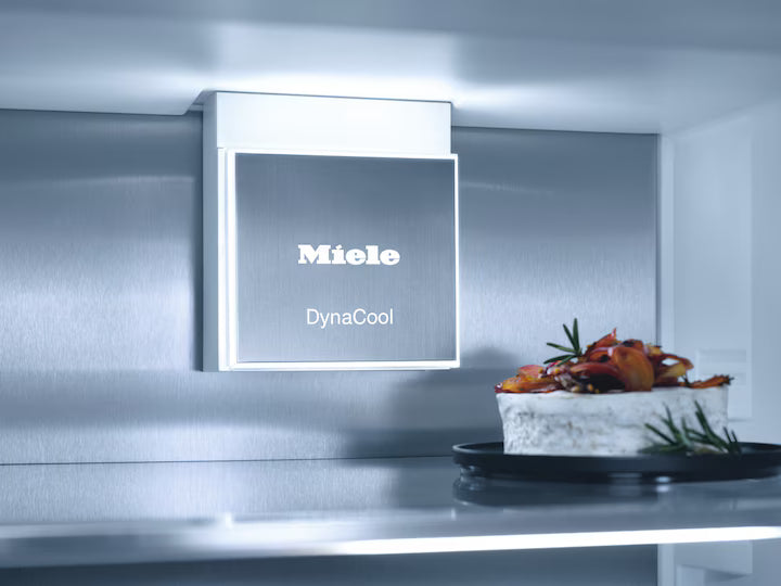 Interior of Miele KFN 7795 C fridge freezer showing DynaCool vent and a cake on a shelf.