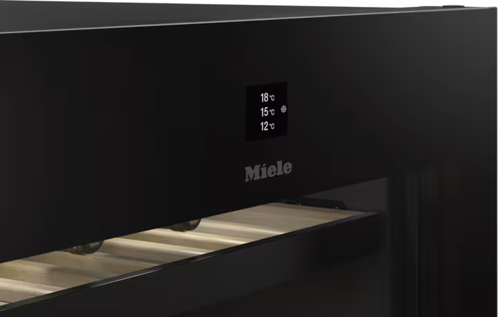 Close-up of Miele KWT 4999 F wine cooler control panel with temperature display and wooden shelves inside.
