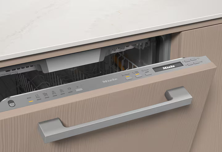 Miele G 7085 SCVi XXL dishwasher partially open, showing control panel with illuminated buttons and wooden front panel.