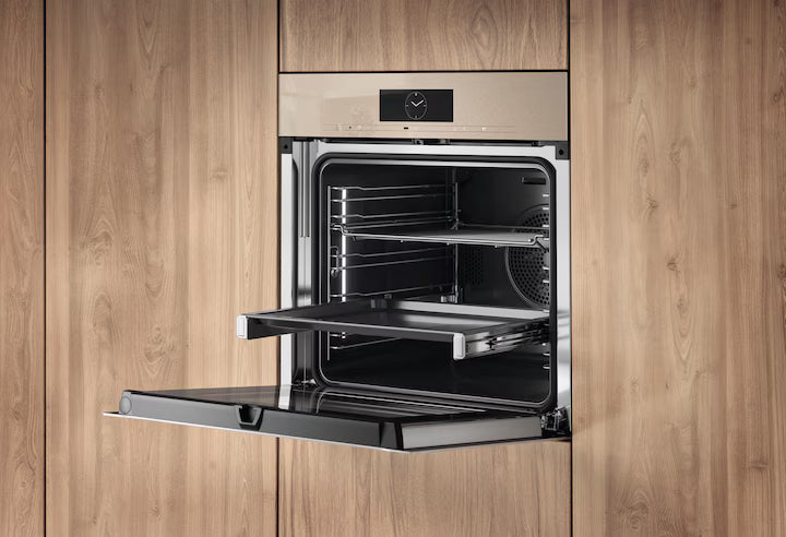 Miele H 7860 BPX ArtLine built-in pyrolytic oven in pearl beige with open door and sliding tray inside wood cabinetry.