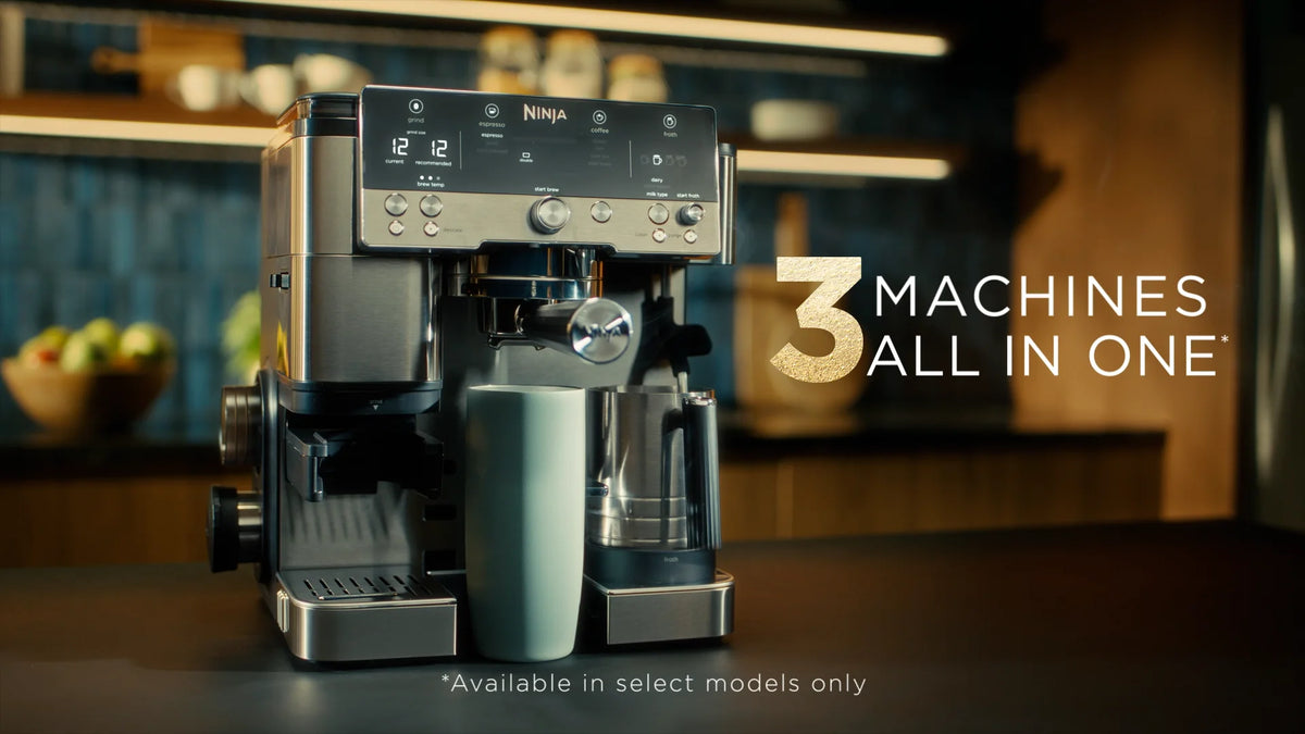Ninja Luxe Café Espresso Bar Coffee Machine in black with a cup and frother on a kitchen counter