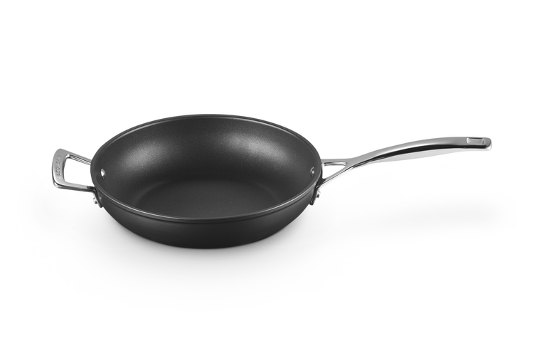 Le Creuset 26cm deep frying pan with toughened non-stick surface and metal handles, angled view.