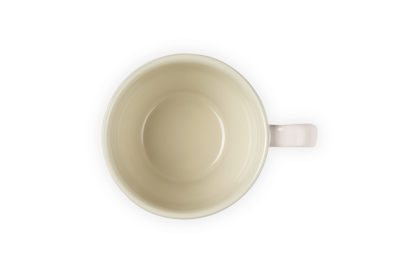 Le Creuset Grang 400ml mug in shell pink, shown from top view with cream interior and handle on right.