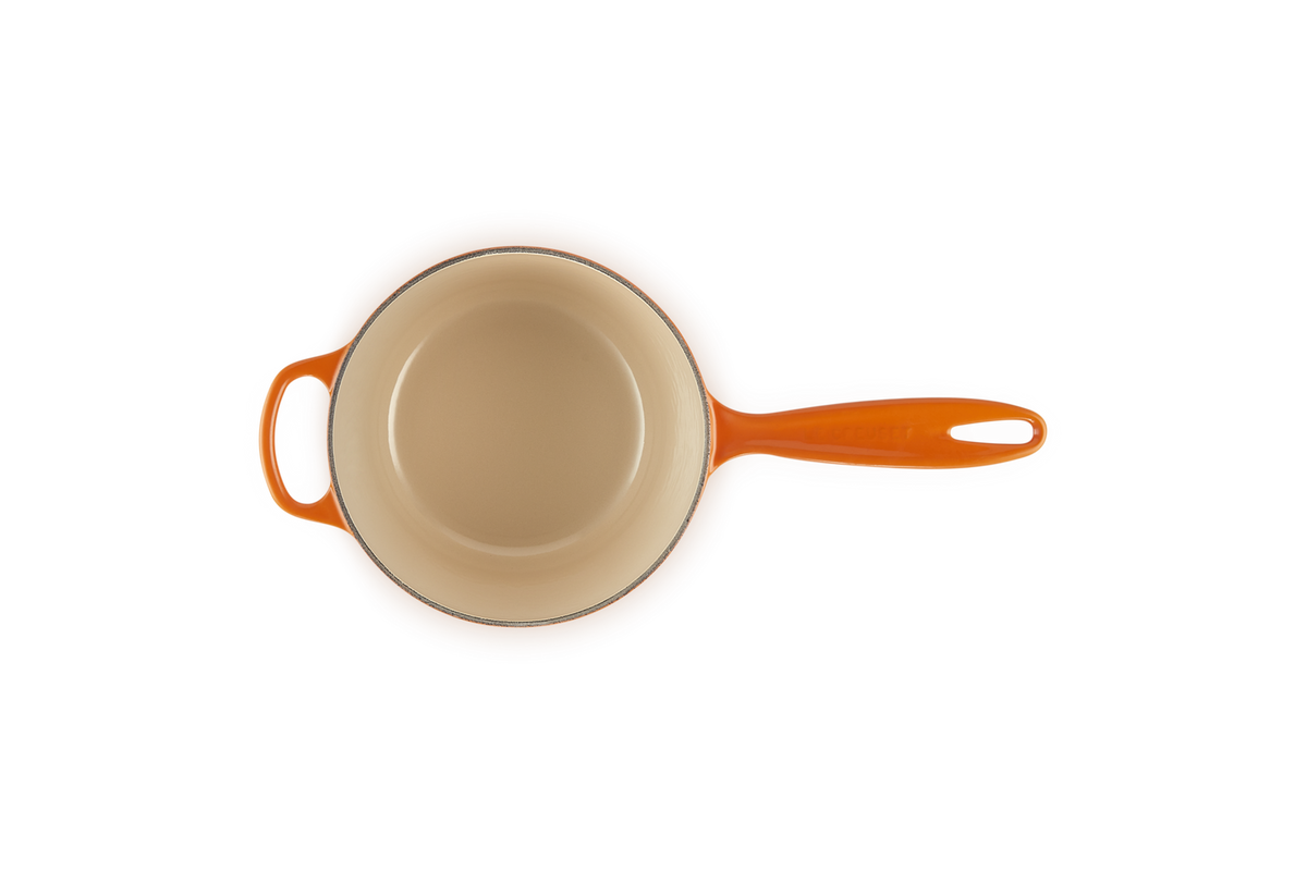 Le Creuset 20cm saucepan in volcanic orange, top view showing cream interior and long handle with helper handle.