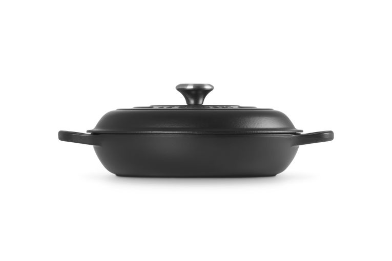 Le Creuset Signature cast iron shallow casserole in satin black, side view with lid on.
