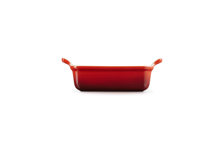 Le Creuset Stoneware Heritage rectangular dish in cerise, side view showing handles and depth.