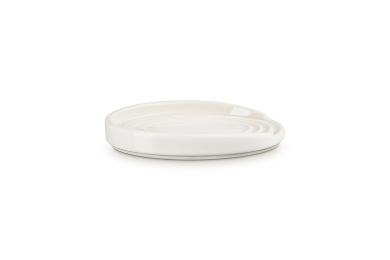 Le Creuset Oval Spoon Rest in meringue white with a glossy finish and raised edges.