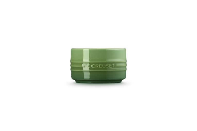 Green Le Creuset stackable ramekin with embossed logo on the side and smooth glossy finish.
