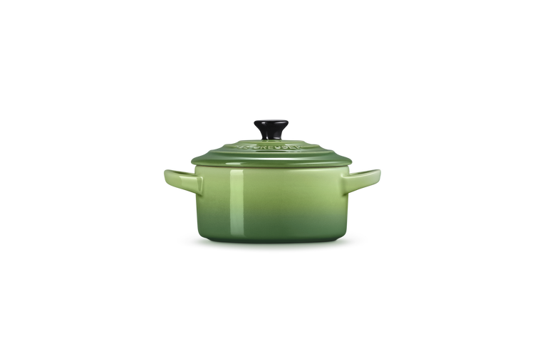 Le Creuset Petite Round Casserole in green with lid and black knob, side view on white background