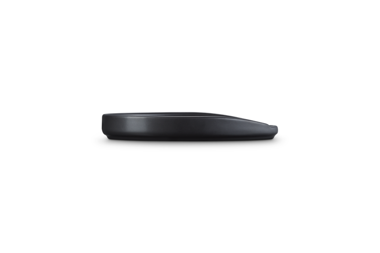 Le Creuset Stoneware Oval Spoon Rest in satin black shown from side profile on white background.