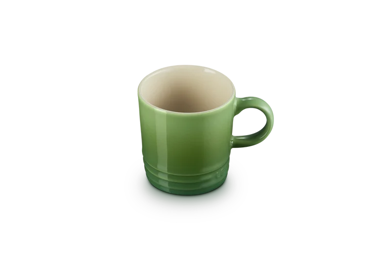 Le Creuset green stoneware espresso mug with bamboo color interior, shown from a slight top angle.