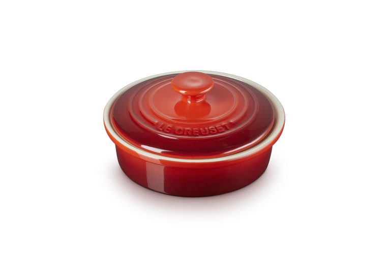 Le Creuset Stoneware Camembert Baker in cerise red with lid, shown from a slight angle on white background.