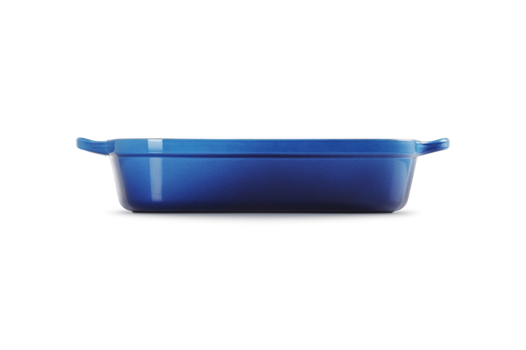 Le Creuset 33cm rectangular cast iron roaster in azure blue, shown from side view.