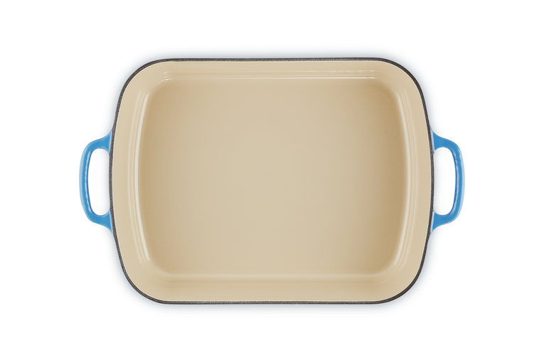 Le Creuset 33cm rectangular cast iron roaster in azure blue with cream interior, top view.