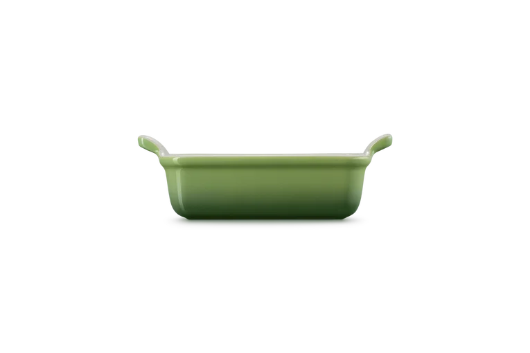 Le Creuset Stoneware Heritage rectangular dish in green, side view showing handles and depth.