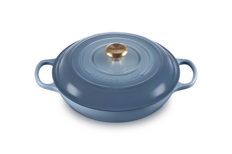 Le Creuset Signature 30cm shallow cast iron casserole in chambray with gold knob lid, front angle view.