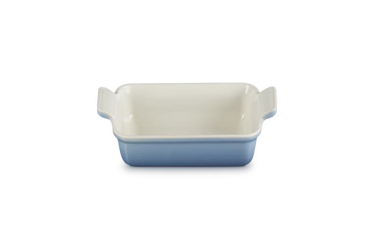 Le Creuset Stoneware Heritage rectangular dish in chambray blue, shown from the front with handles visible.